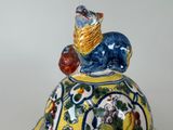 a ceramic figurine of a cat sitting on top of a turtle