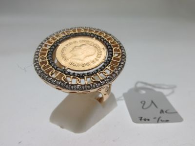 une bague en or surmontée d'une pièce de monnaie
