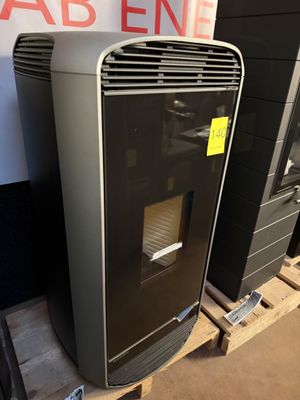 a black and gray refrigerator sitting on a pallet in front of a sign
