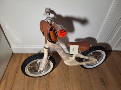 un petit vélo en bois avec une selle à l'arrière