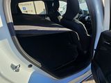 a white car with its door open and a black seat in the back