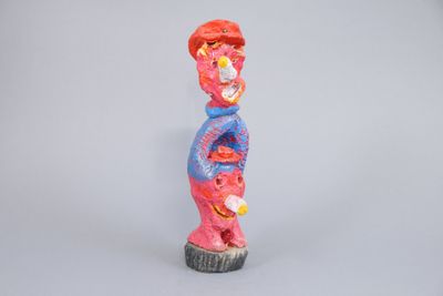 brightly colored figurine of a man with a baseball cap on his head
