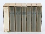 six livres sont alignés sur une surface blanche