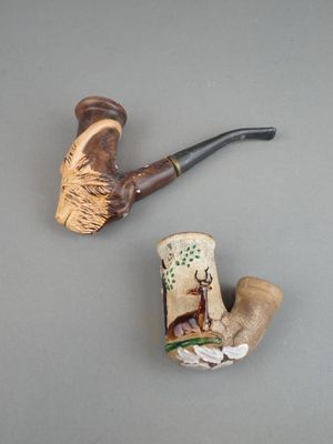 une photo représentant une pipe et une figurine posées sur une table
