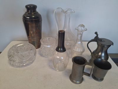 une table sur laquelle se trouvent de nombreux objets en verre
