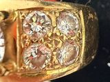 a close up of a gold ring with diamonds on it