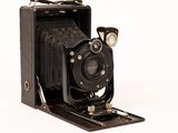un vieil appareil photo noir posé sur une caisse en bois