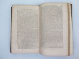 an open book on a white table with a blue background