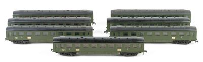 three green train cars sitting next to each other on a white surface