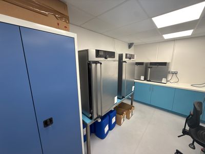 an image of a kitchen with a refrigerator and blue cabinets