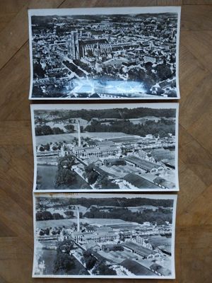three old black and white photos of a city with a clock tower