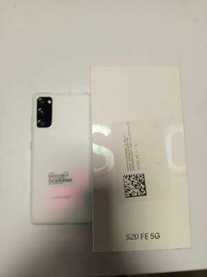 une boîte ouverte contenant un téléphone Samsung S20 blanc, posée sur une table