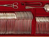 silverware in a red box with scissors, spoons, and a pair of scissors