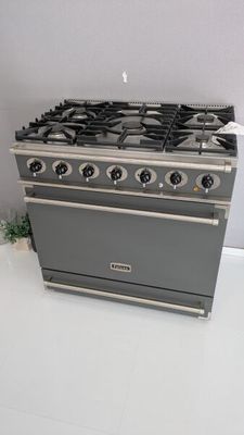 un réchaud gris à quatre feux et une plante en pot