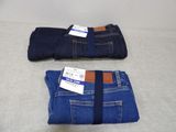 two pairs of men ' s jeans with tags on them sitting on a table