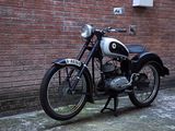a black and white motorcycle parked in front of a brick wall