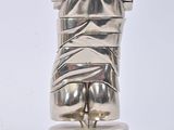 silver metal sculpture of a torso on a pedestal on a white background