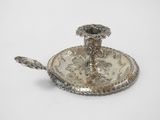 a silver plate with a silver candle holder on it