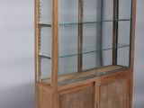 an old wooden display case with glass shelves and doors