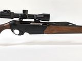le fusil est posé sur un support transparent équipé d'une lunette de visée