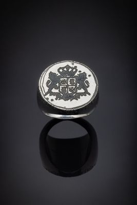 une bague en argent sur laquelle sont gravés un lion et une couronne