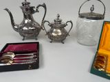 a silver tea pot and a silver tea set in a box