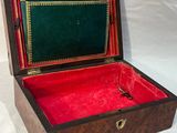 une petite boîte en bois doublée de velours rouge