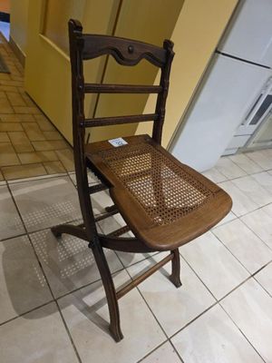une chaise en bois posée sur un sol carrelé