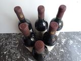 six bottles of wine sitting in a wine holder