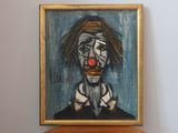 a painting of a clown that is hanging on the wall