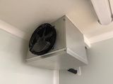 a fan on the wall in a room with white walls