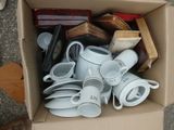 a cardboard box full of white coffee cups and saucers