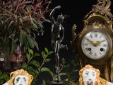 deux figurines de lions assis à côté d'une horloge