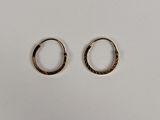 une paire de boucles d'oreilles en or sur fond blanc