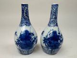 une paire de vases bleus et blancs posés sur une table blanche