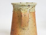 a close up of a small vase on a white surface