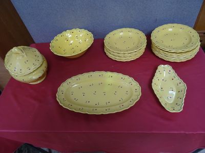 a table with a red table cloth and yellow dishes on it
