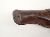 a close up of a brown leather holster on a white surface