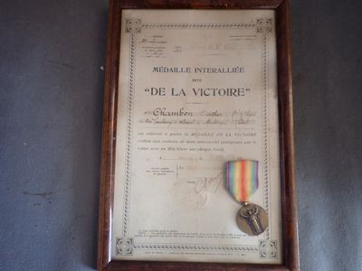 photo encadrée représentant une médaille et un ruban accrochés au mur