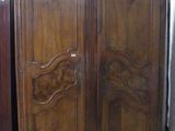 une armoire en bois dans une pièce où se trouve une horloge
