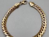 a gold bracelet with a clasp on a white background