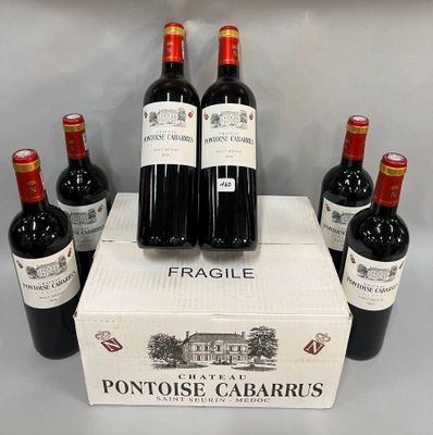 six bouteilles de vin rouge sont posées dans une boîte sur une table