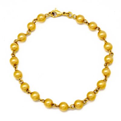a gold beaded bracelet on a white background