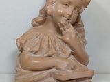 a small statue of a girl sitting on a box