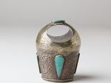 an old silver vase with a turquoise stone in the middle