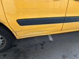 a yellow car parked in a parking lot with its door open