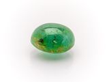 a close up of a green emerald stone on a white surface