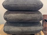 three pillows stacked on top of each other on top of a table