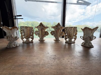 five vases sitting on a table in front of a window