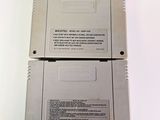 two nintendo game cartridges sitting on top of each other on a white surface